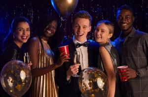 Five people at a party, standing together with balloons and drinks indicating importance of a reliable prom limo Chicago service