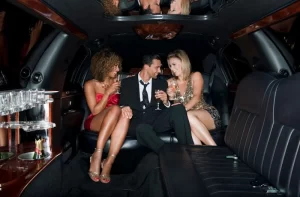 Three people in formal attire enjoy champagne during a party limo rental Chicago