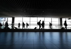 Travelers walking in an airport terminal showcasing the value of Airbnb Chicago airport transfers