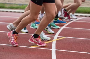 Feet of Chicago Marathon participants in bright shoes, supported by local transportation.